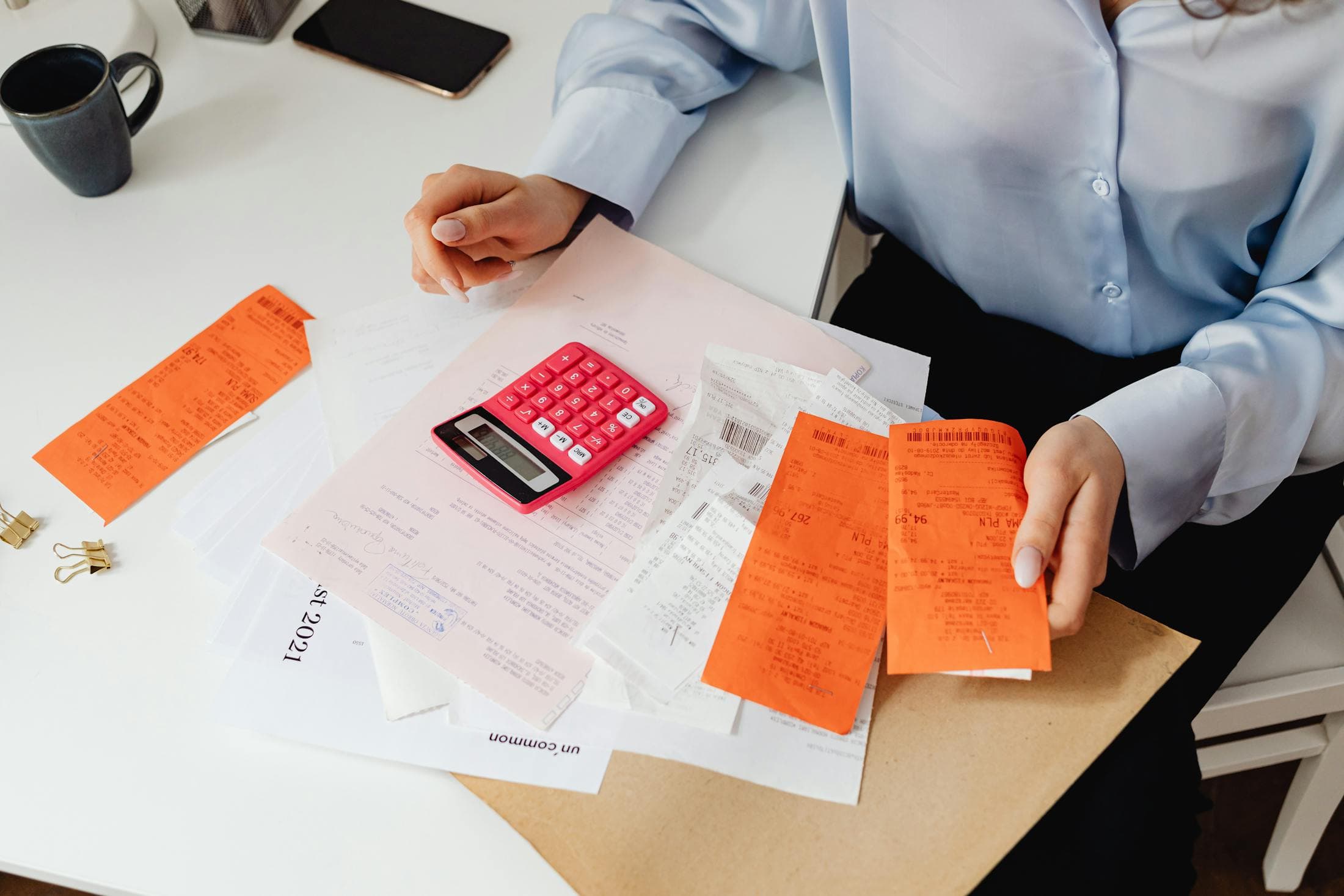 Receipts and a calculator laid out on top of financial paperwork.