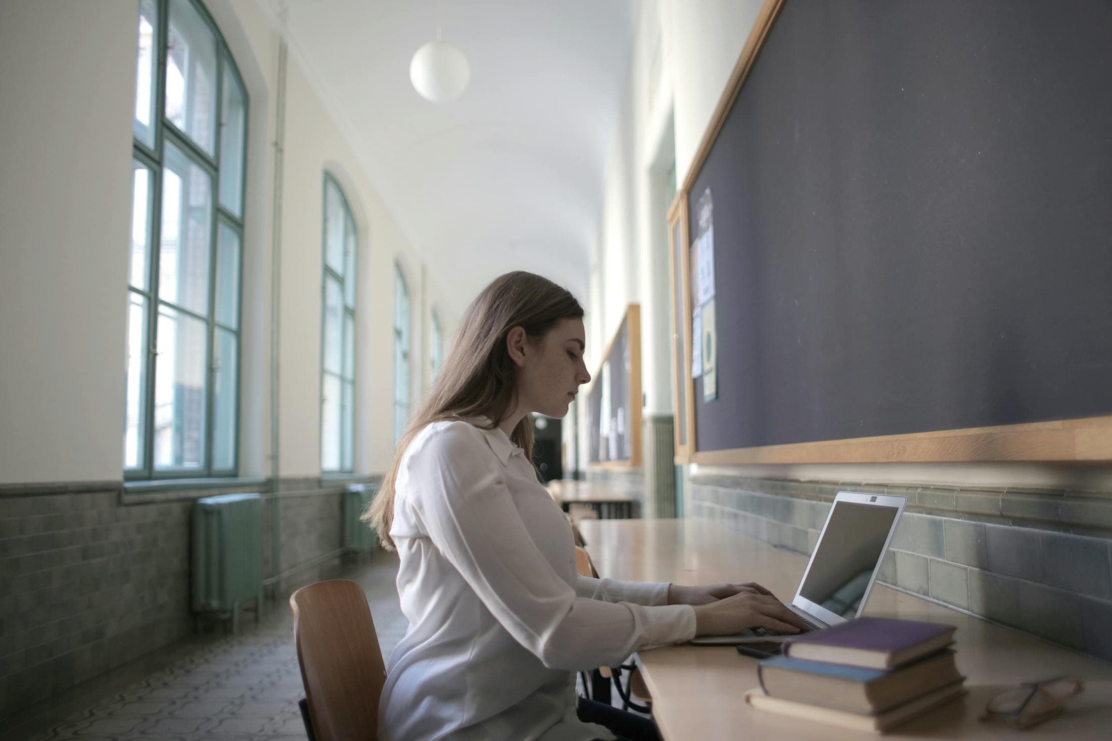 Young student working on a laptop in a study hall.