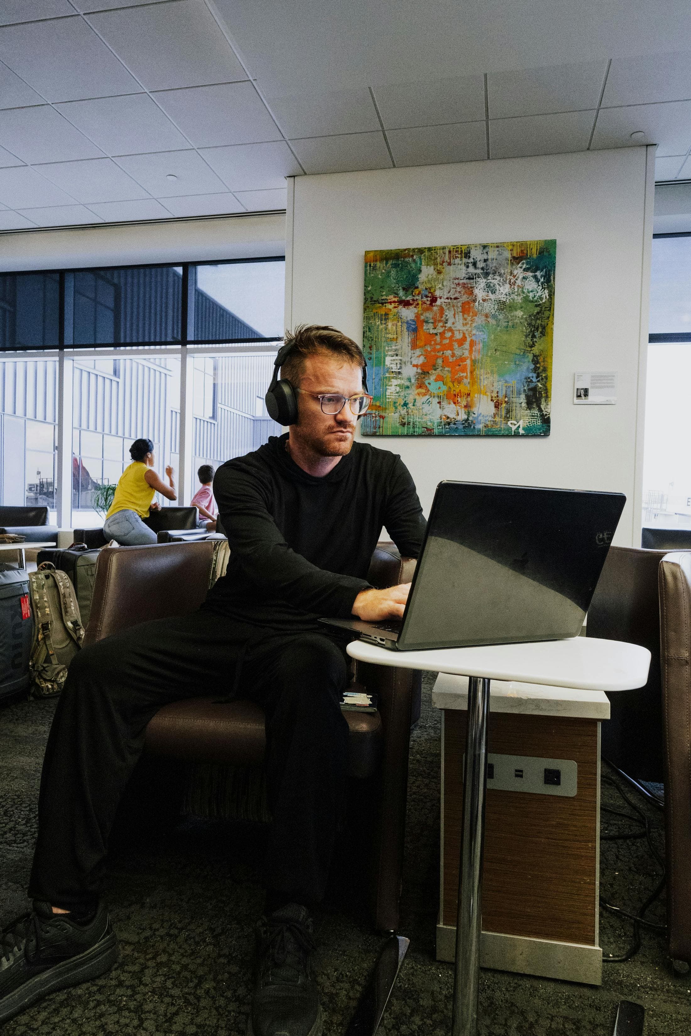 Traveler working on a laptop in an airport lounge.