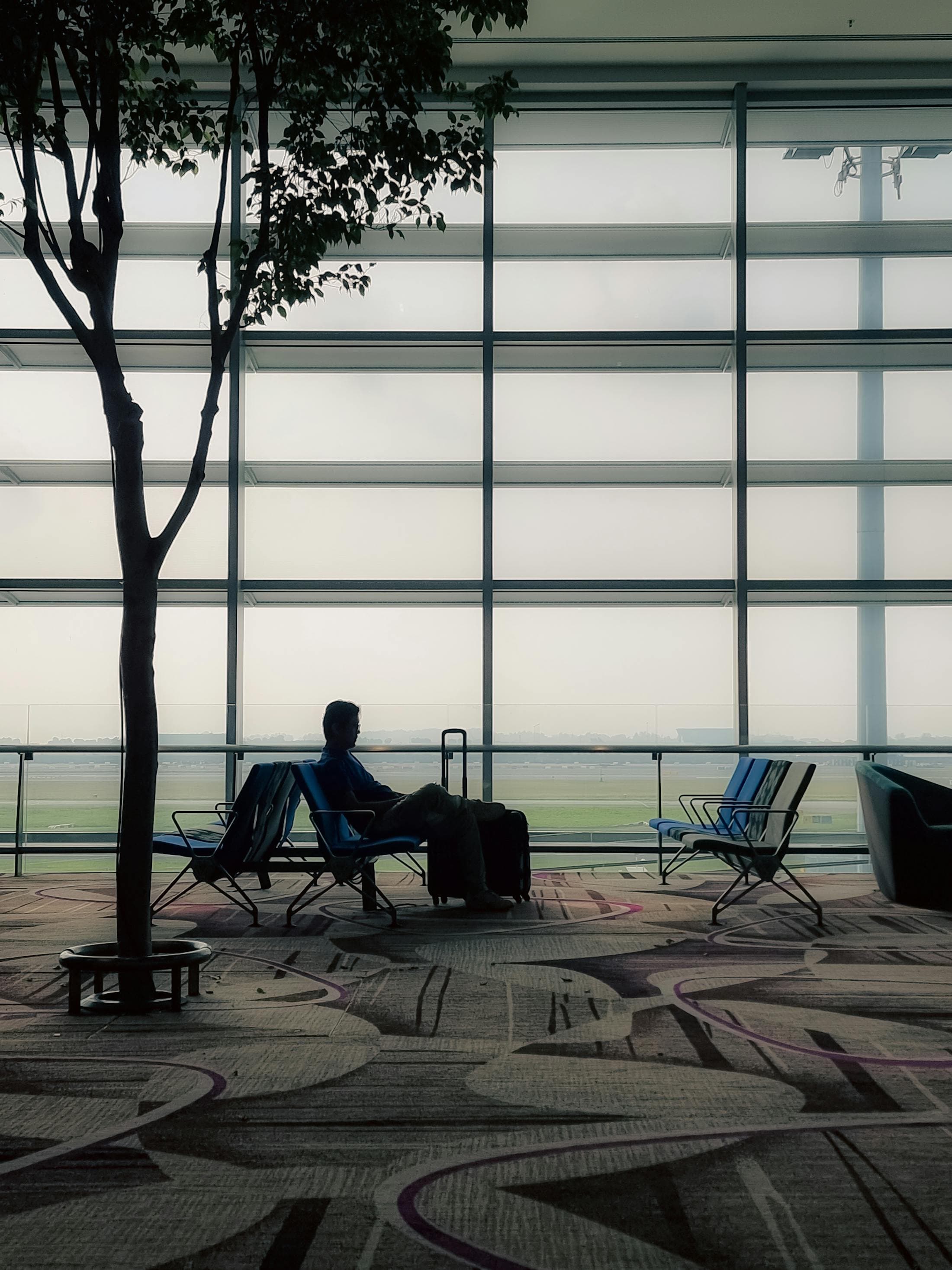 Solo traveler seated in a quiet airport lounge.
