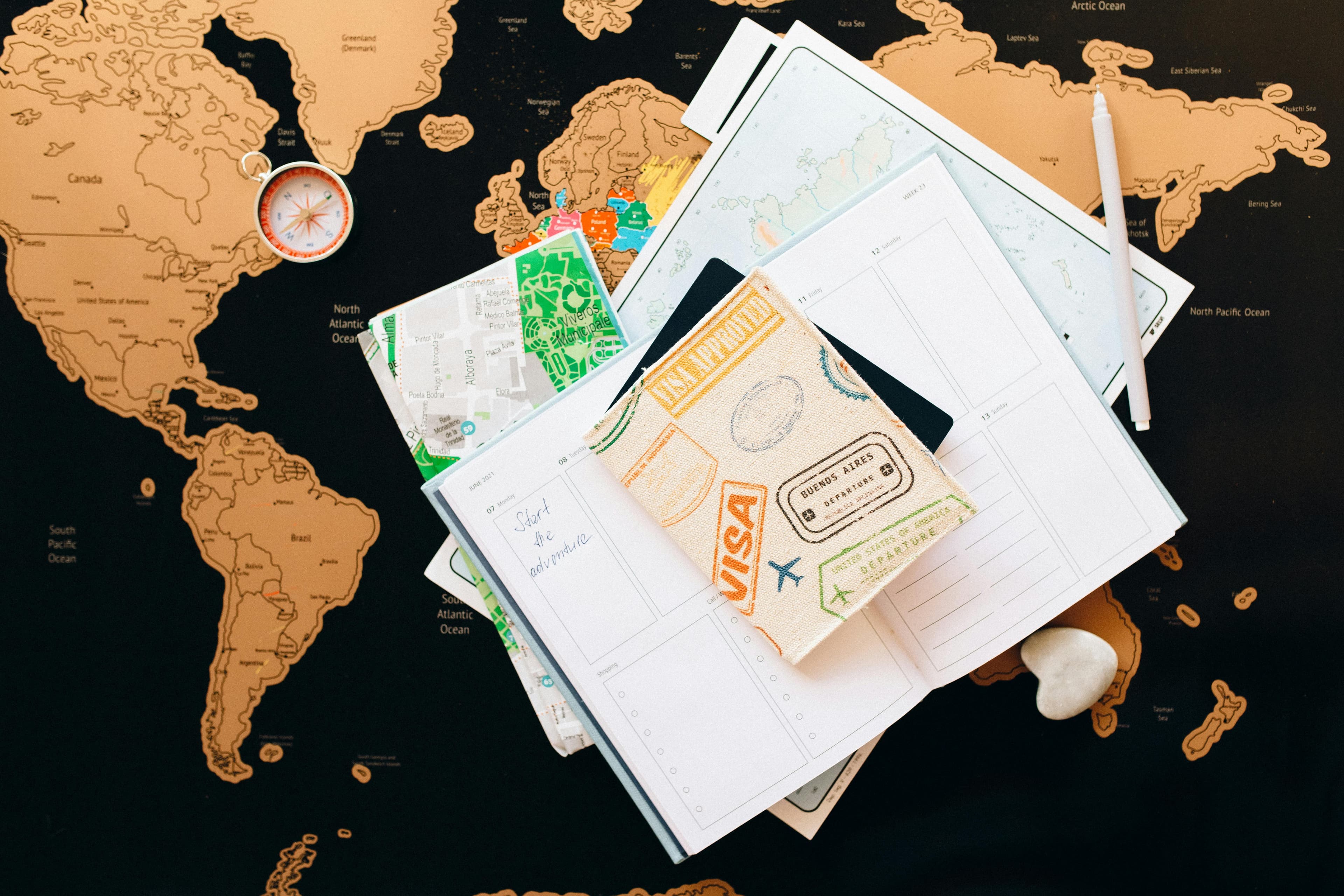 Passport and travel planner resting on a world map.